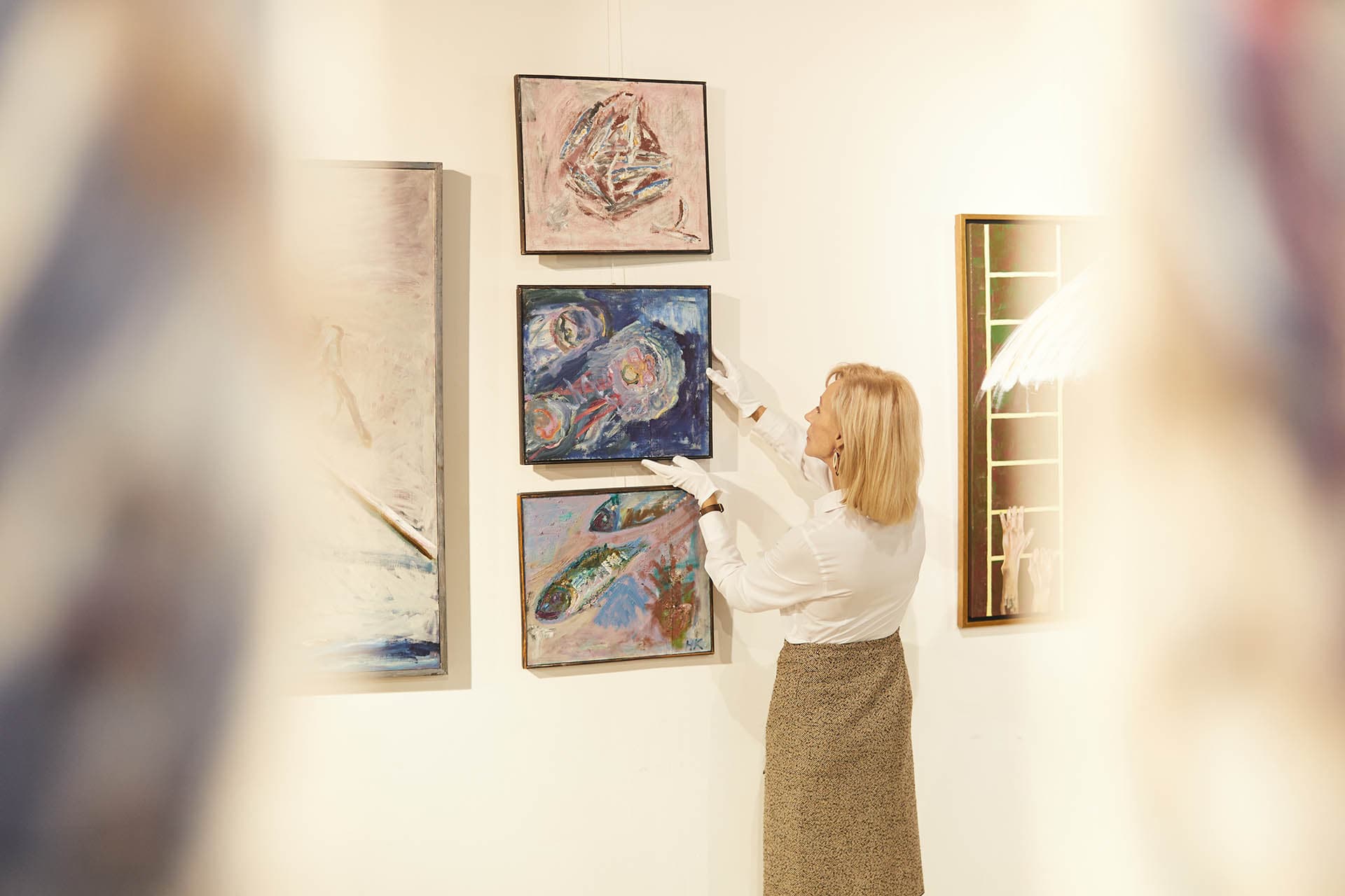 Person considering frame options in front of artwork